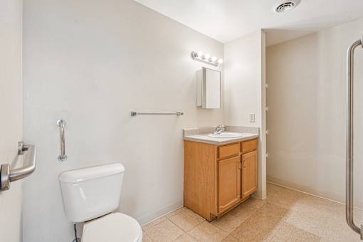 A white toilet sits next to a sink in a small bathroom.
