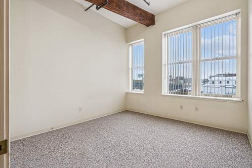 Empty room with a window overlooking a cityscape.