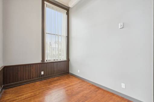 A room with a window and wooden floors.