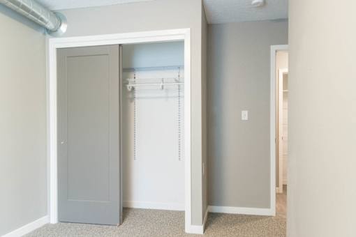 A white closet with a grey door is open.