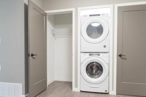 A white front load washing machine is in a laundry room.