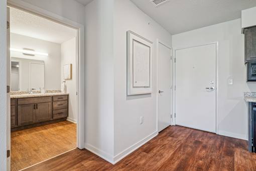 A bathroom with a wooden floor and white walls.
