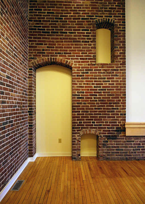 A yellow door is in a brick wall.