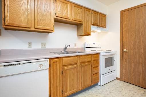 A kitchen with wooden cabinets and white appliances.