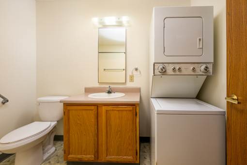 A small bathroom with a toilet, sink, and a built in oven.