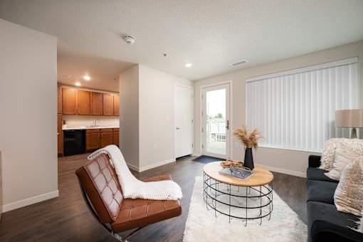 A living room with a brown leather chair and a white couch.