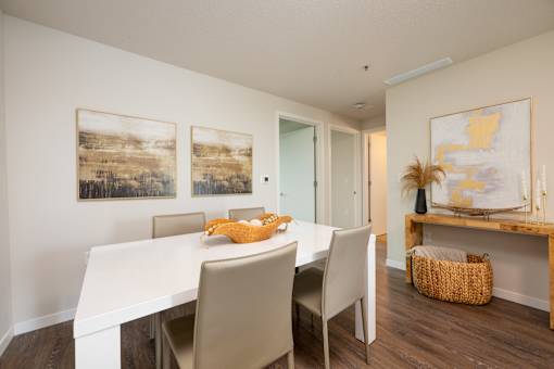 A dining room with a white table and chairs.