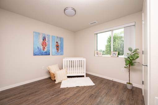 A baby's room with a white crib and two paintings on the wall.