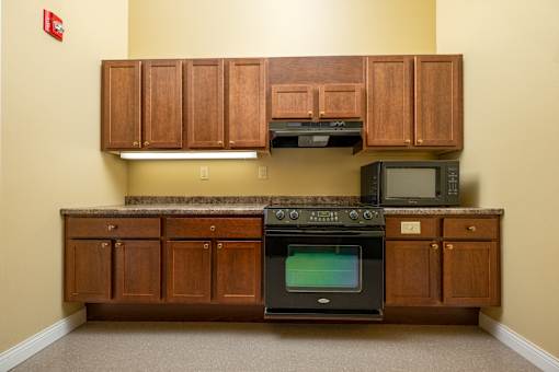 A kitchen with wooden cabinets and a black oven.