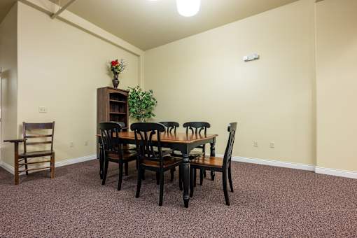 A dining room with a wooden table and chairs.
