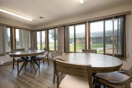 A dining room with a table and chairs.