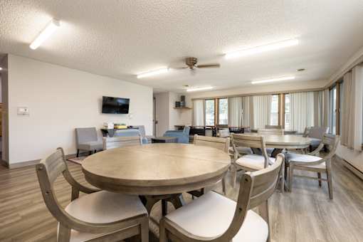 A modern dining room with a large table and chairs.