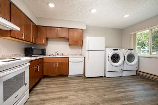 A kitchen with white appliances and wooden cabinets.