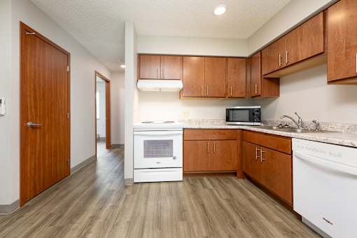 A kitchen with wooden cabinets and white appliances.