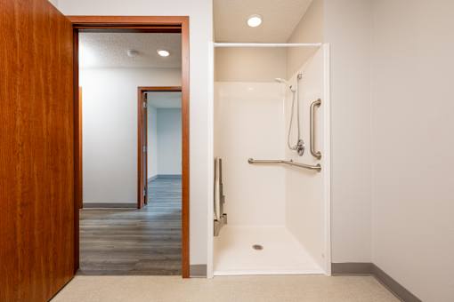 A white bathroom with a wooden door.