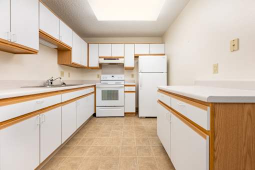 A kitchen with white cabinets and a white oven.