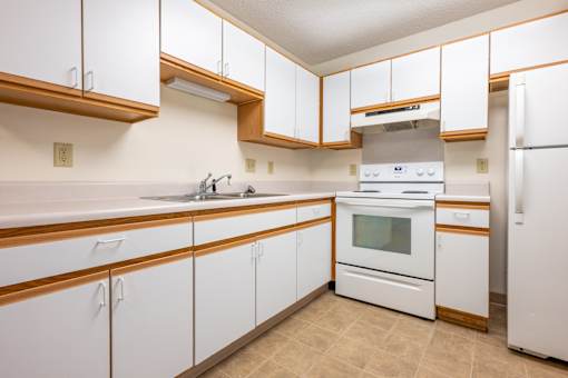 A kitchen with white cabinets and a white oven.