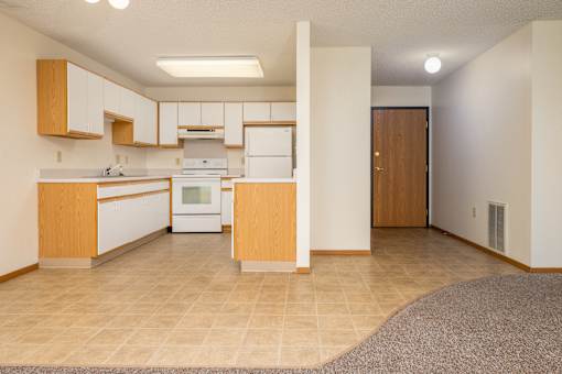 A kitchen with white appliances and wooden cabinets.