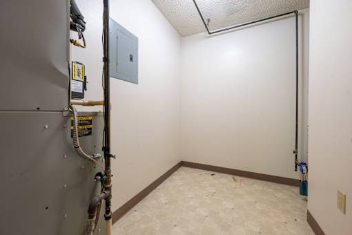 A room with a white wall and a brown baseboard heater.