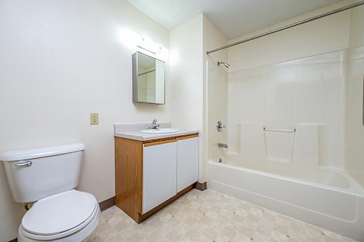 A white toilet sits next to a sink in a small bathroom.