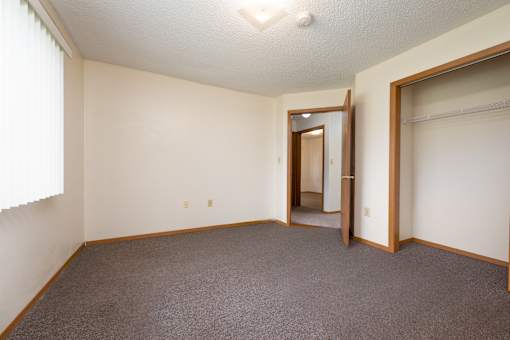 A room with a carpeted floor and a doorway leading to another room.