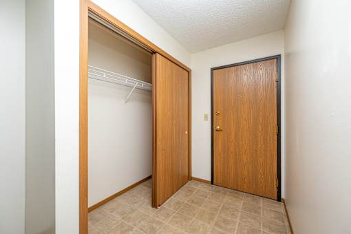 A room with a white wall and a brown door.