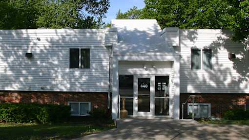 A white building with a black door and windows.