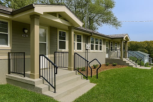 A house with a grey front and a black railing.