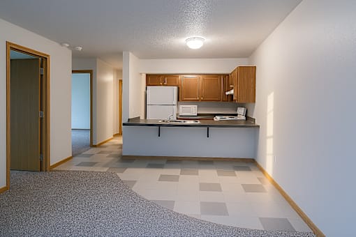 A kitchen with white appliances and wooden cabinets.