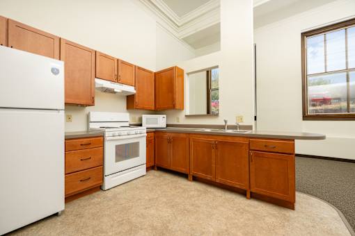 A kitchen with white appliances and wooden cabinets.
