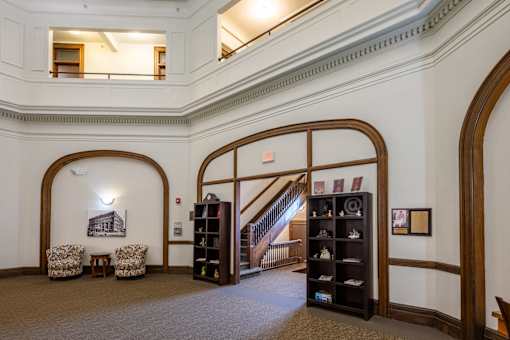 A room with a staircase and a bookcase.