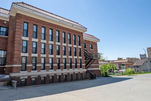 A red brick building with a staircase in front.
