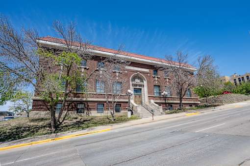 A large red brick building with a staircase leading to the front door.