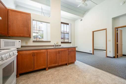 A kitchen with wooden cabinets and a white stove top oven.