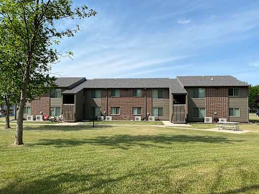 A large building with a green lawn in front.