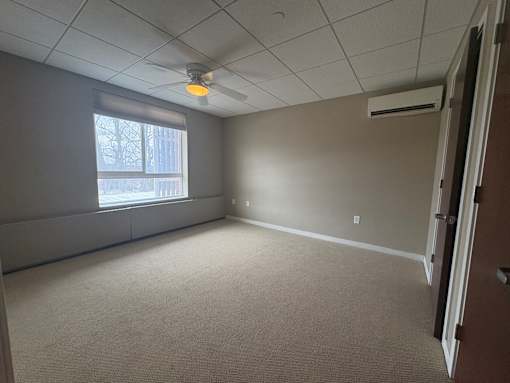 A room with a window and a ceiling fan.