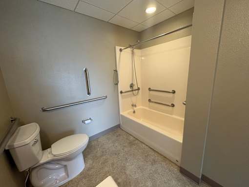 A white toilet sits next to a walk-in shower in a bathroom.