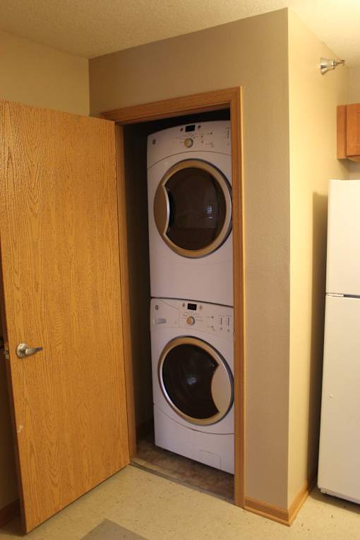 Two washing machines are installed in a cabinet.