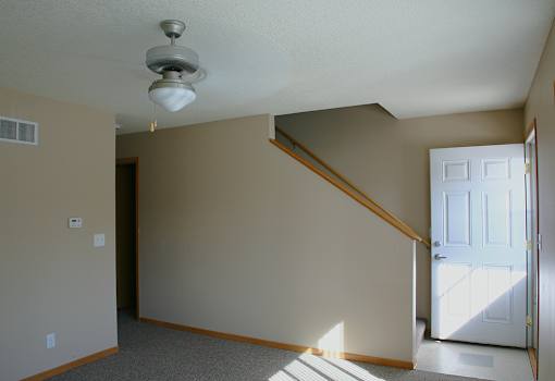 A room with a light on the ceiling and a door on the right.