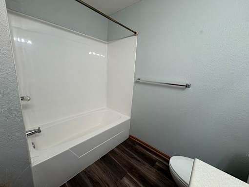 A white bathroom with a toilet and a bathtub.