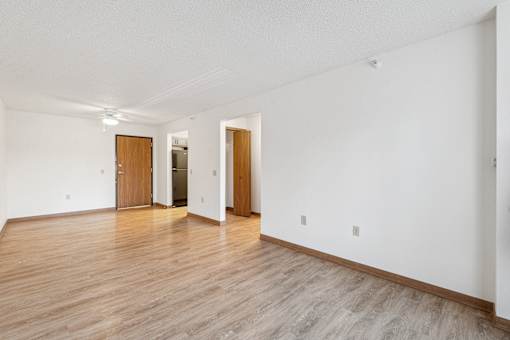 A room with wooden floors and white walls with two doors.