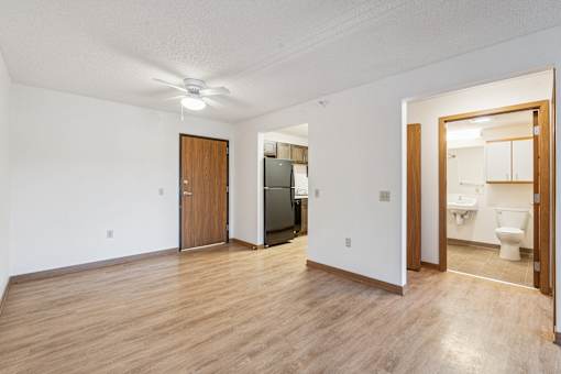 A room with a wooden floor and a ceiling fan.