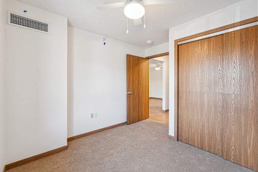 A room with a carpeted floor and a wooden door.