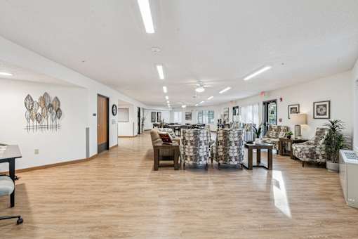 A spacious waiting room with patterned chairs and a wooden floor.