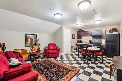 A living room with red chairs and a black and white checkered floor.
