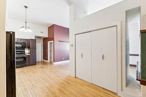 A kitchen with wooden floors and white cabinets.
