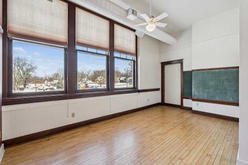 A room with a blackboard and a window overlooking a snowy landscape.