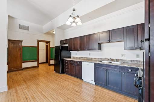 A kitchen with dark wood cabinets and a white dishwasher.