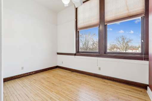 A room with a window and wooden flooring.