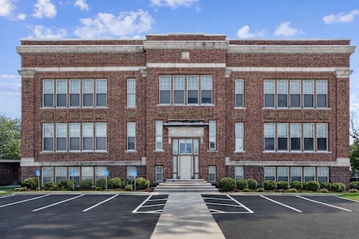A large red brick building with a white door and windows.